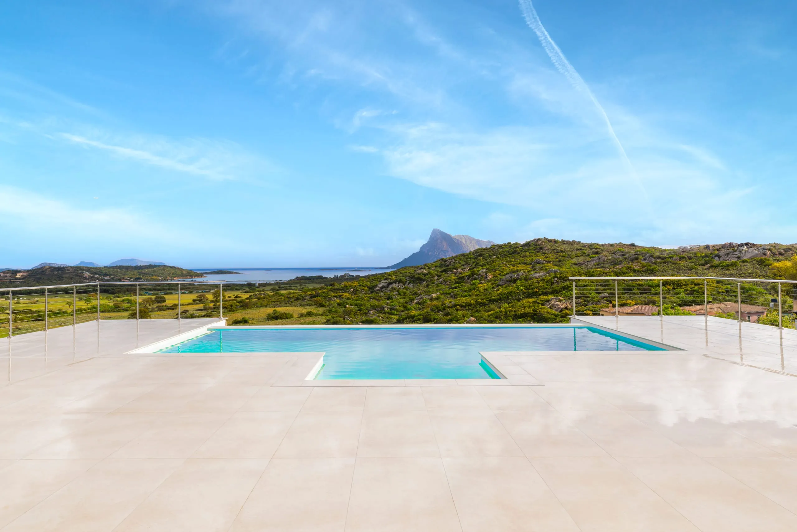Ringhiera inox AISI 316 a cavi con fascione incassato a bordo piscina in Sardegna.