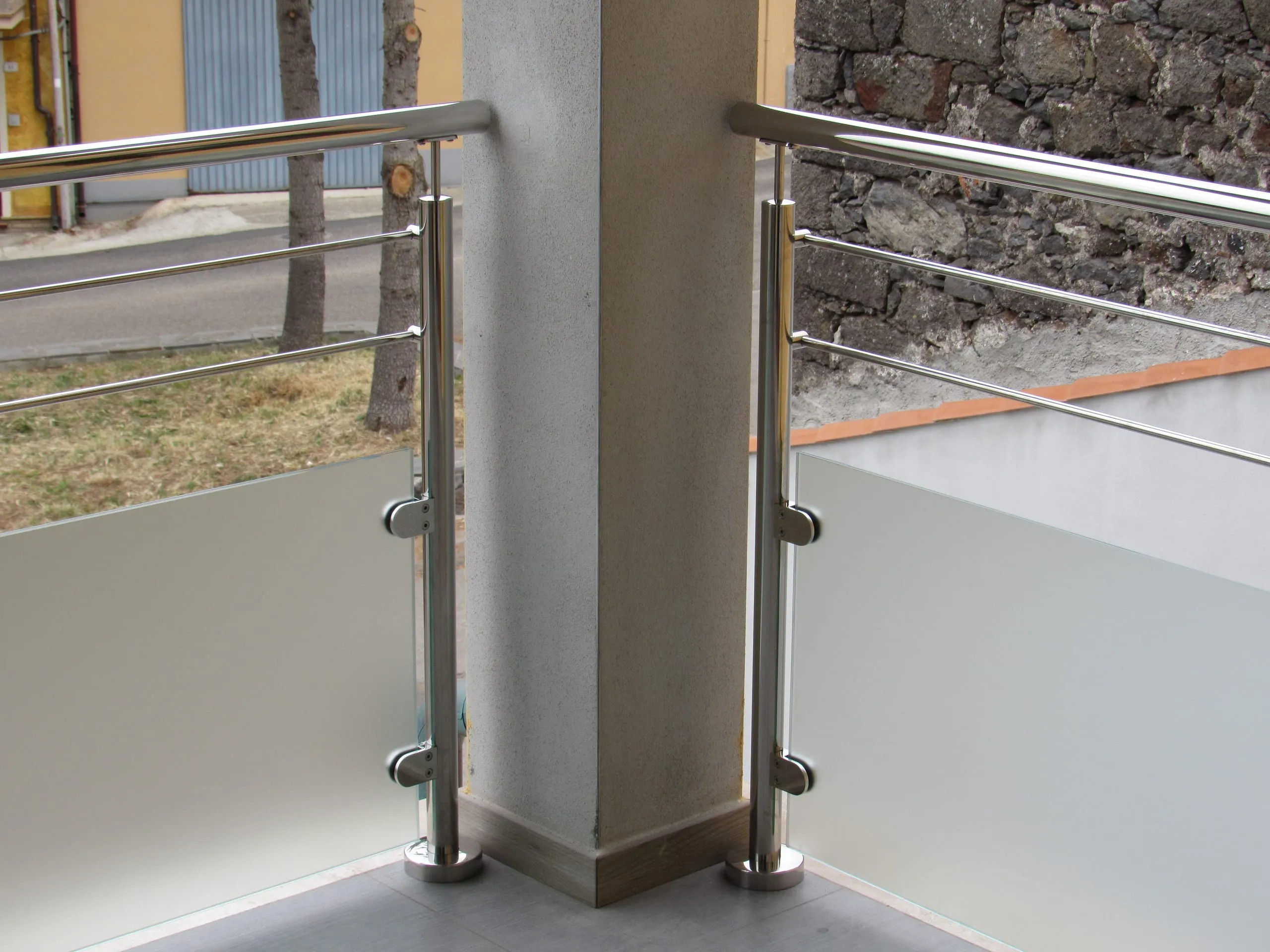 Vista laterale della ringhiera esterna inox con vetro satinato a Pozzomaggiore.