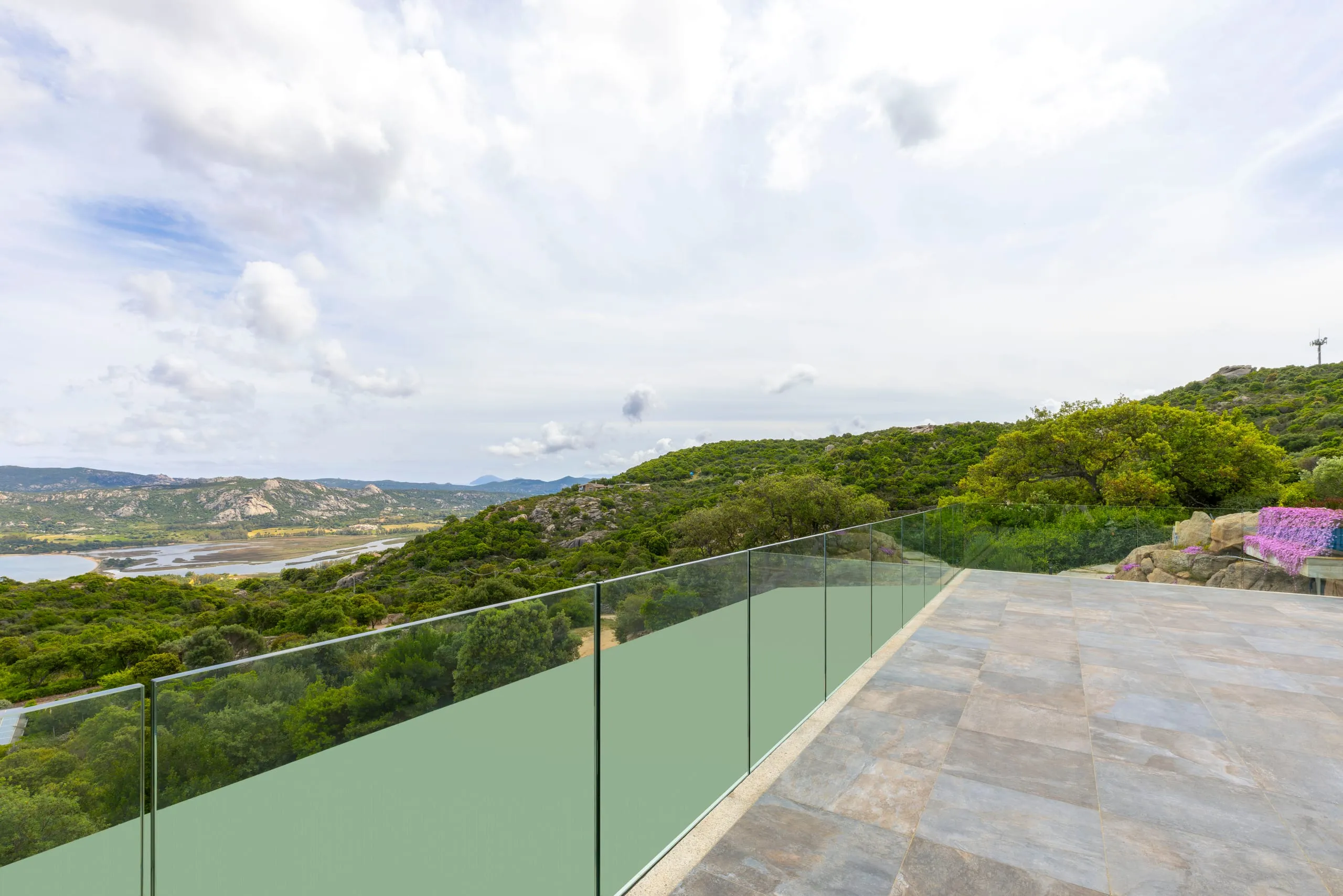 Affaccio dal terrazzo della villa con parapetto in vetro a Porto Cervo, Arzachena SS — vista isole Li Nibani