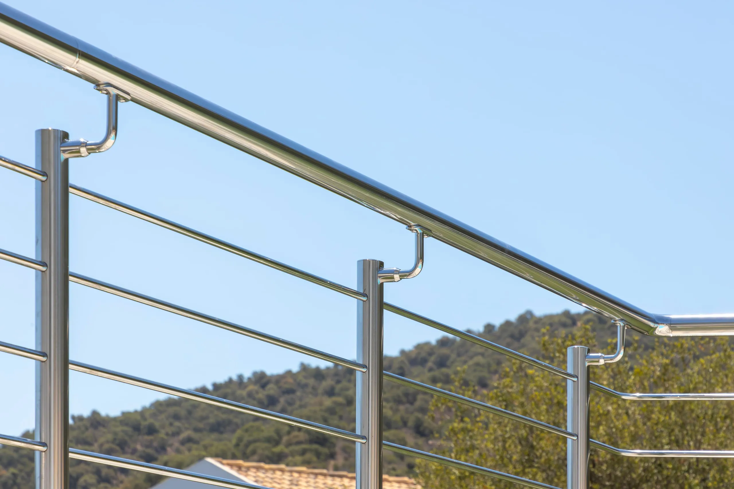 Ringhiera inox AISI 316 lucida a bordo piscina in Sardegna, con corrimano disassato anti-scavalcamento e montanti 42,4x2 mm.