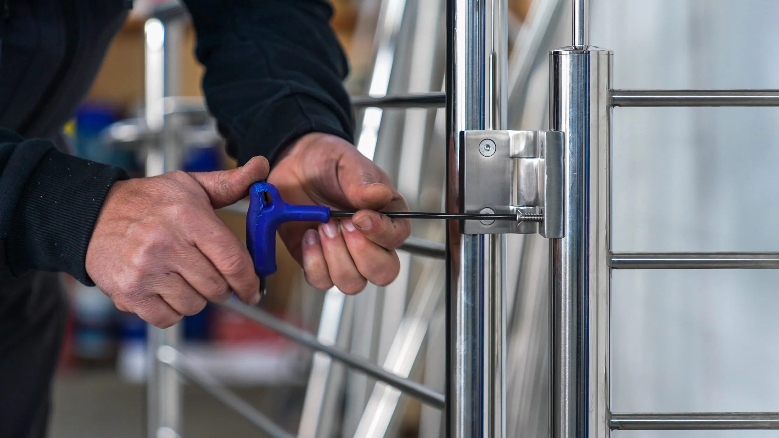 Montaggio manuale di una ringhiera in acciaio inox AISI 316: squadra di montaggio Steelglass serra i pali con brugola per garantire precisione millimetrica