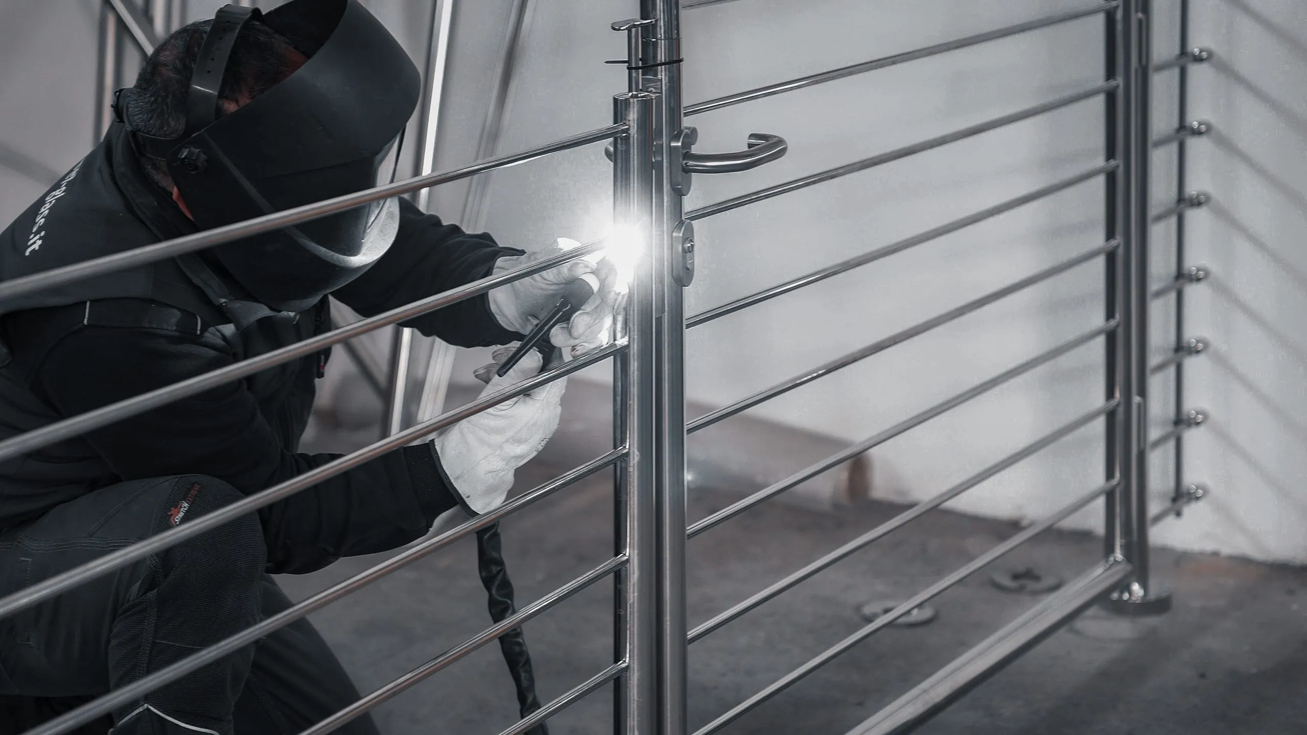 Operaio Steelglass con maschera esegue saldatura TIG su palo di ringhiera in acciaio inox AISI 316: produzione interna Villacidro